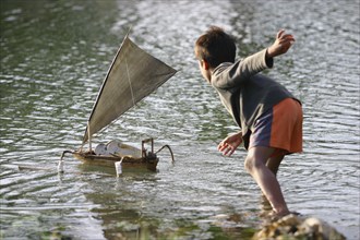 Un enfant de pêcheur joue avec son bateau
