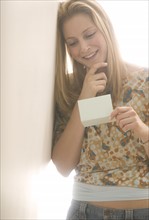 Young female reading a note.