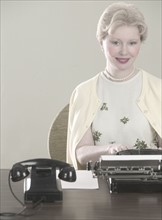Woman at desk with typewriter.