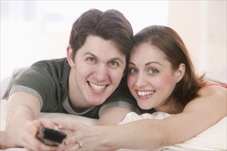Smiling couple with remote control.