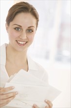 Smiling woman with papers.