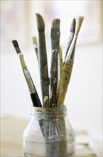 Paintbrushes in glass jar.