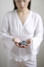 Young woman holding stones.