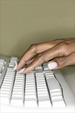 A woman's hand on computer keyboard.