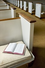 Interior of a church with Bible on a pew.