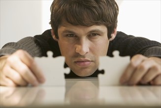 Man connecting puzzle pieces.