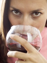 A woman sipping red wine.