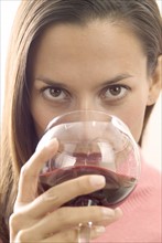 A woman sipping red wine.