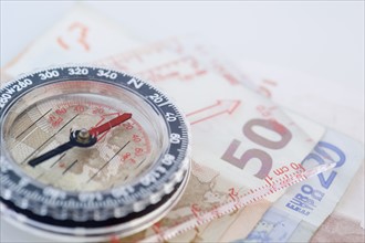 Closeup of compass with money.