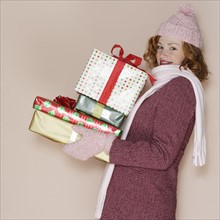 Woman carrying pile of presents.