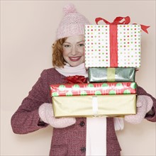Woman holding stack of presents.