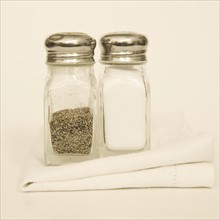 Salt and pepper shakers with napkin.
