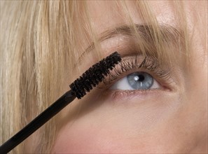 Woman's eye with mascara brush.