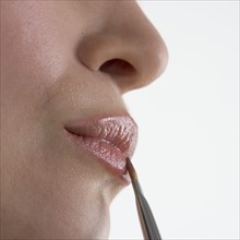 Profile of woman's lips with brush.