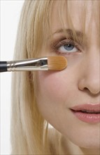 Closeup of cosmetic brush on face.