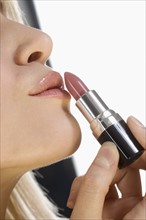 Profile of lips with lipstick tube.