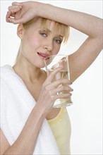 Woman with towel drinking water.