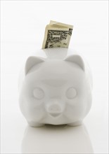 Piggy bank with dollar bill.
