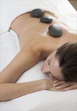 Woman on massage table with stones.