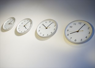 Row of clocks indicating different times.