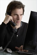 Man on phone at computer.