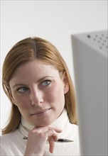 Thoughtful woman at computer.