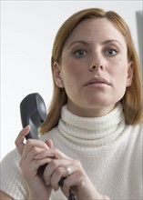 Woman covering mouthpiece of phone.