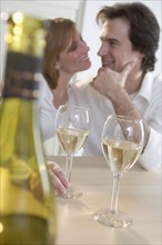 Couple at table with white wine.