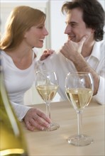 Laughing couple with white wine.