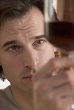 Closeup of man looking at wine.