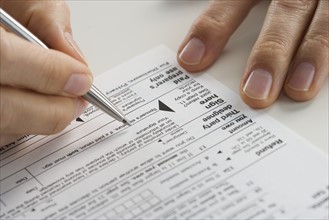 Closeup of hands with tax form.