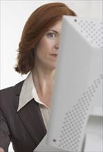 Businesswoman with face hidden by computer.