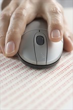 Hand on mouse with binary code.