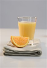 Glass of juice and orange slice.