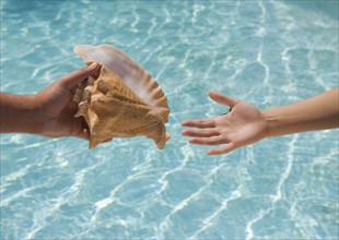 Giving conch shell to someone.