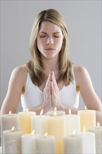 Woman meditating by candlelight.