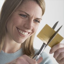 Woman cutting up credit card.