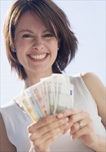 Woman holding Euro bills.