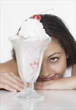 Woman smiling at ice cream sundae.