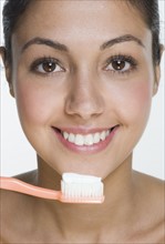 Smiling woman with toothbrush.