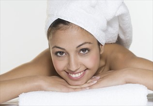 Smiling woman with towel on head.