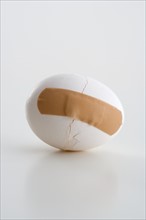 Cracked egg with bandage.
