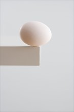 Egg on edge of table.