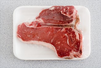 Raw steak on Styrofoam tray.