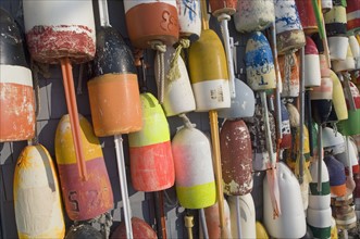 Colorful buoys hanging against wall.