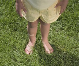 Child standing in bare feet.