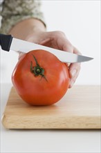 Hand slicing tomato.