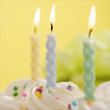Closeup of lit candles on a cake.