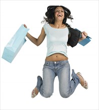 Young woman jumping with shopping bags.