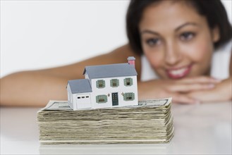 Woman with miniature house and money.